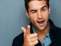 Der Mann zwinkert und zeigt mit dem Finger in Richtung des Betrachters