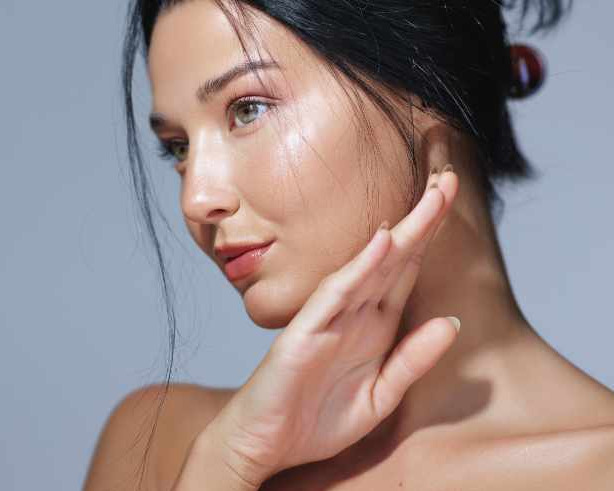 Lachende Frau die Gurken vor ihren Augen h&auml;lt