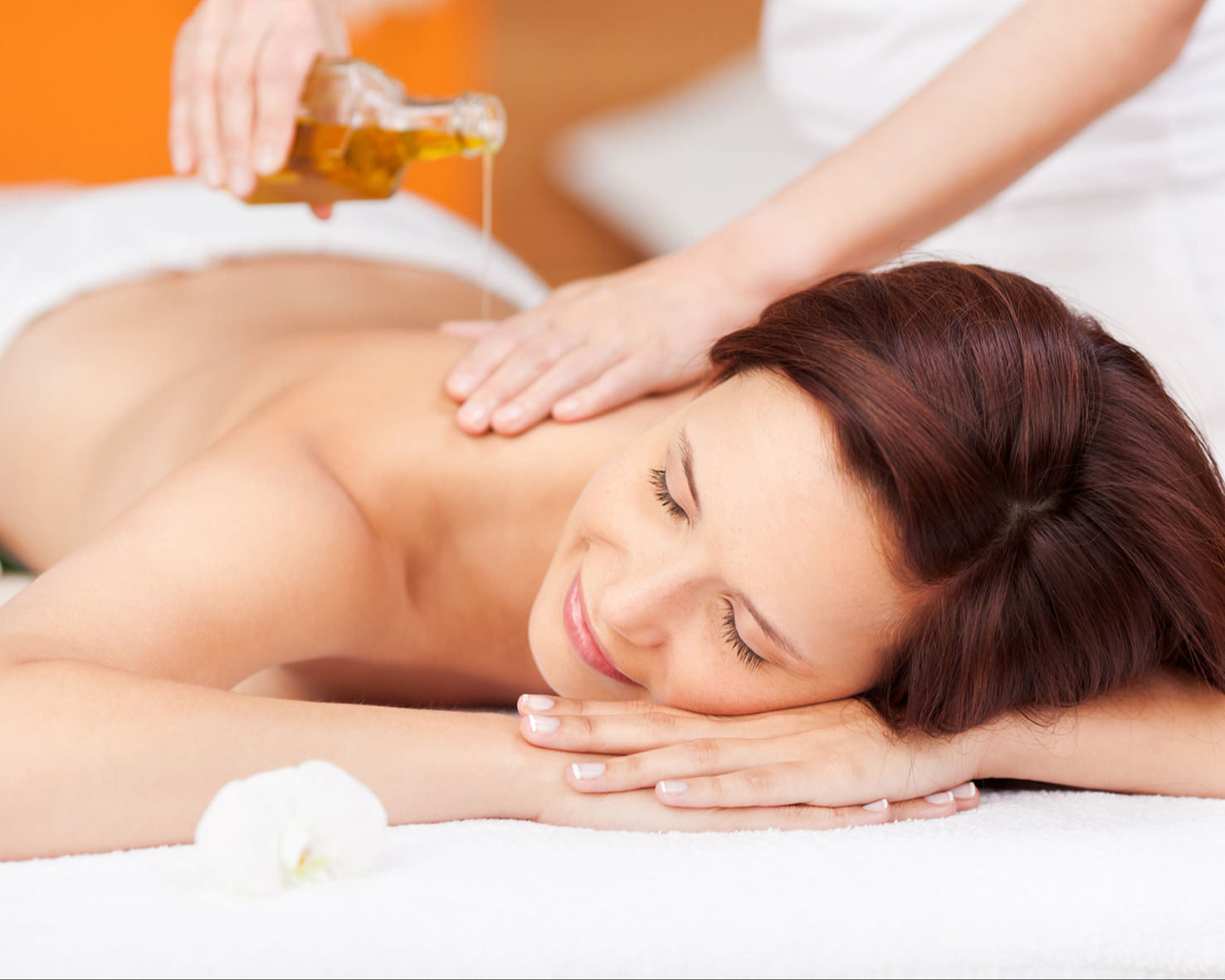 Eine Frau der Aroma-&Ouml;l auf den R&uuml;cken gegossen wird.