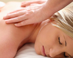 Eine blonde Frau die massiert wird.