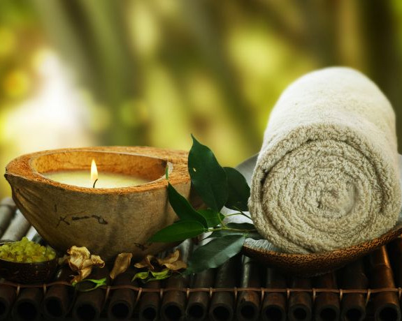 Eine gr&uuml;ne Kerze mit einem hell gr&uuml;nen Handtuch