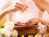 Frau die von einer hand auf die andere &Ouml;l tr&Ouml;pfelt